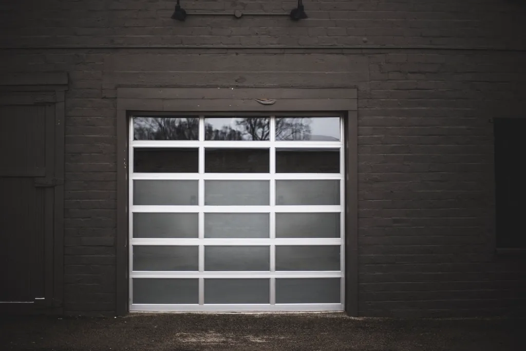 a modern glass-panel garage door set into a dark wall