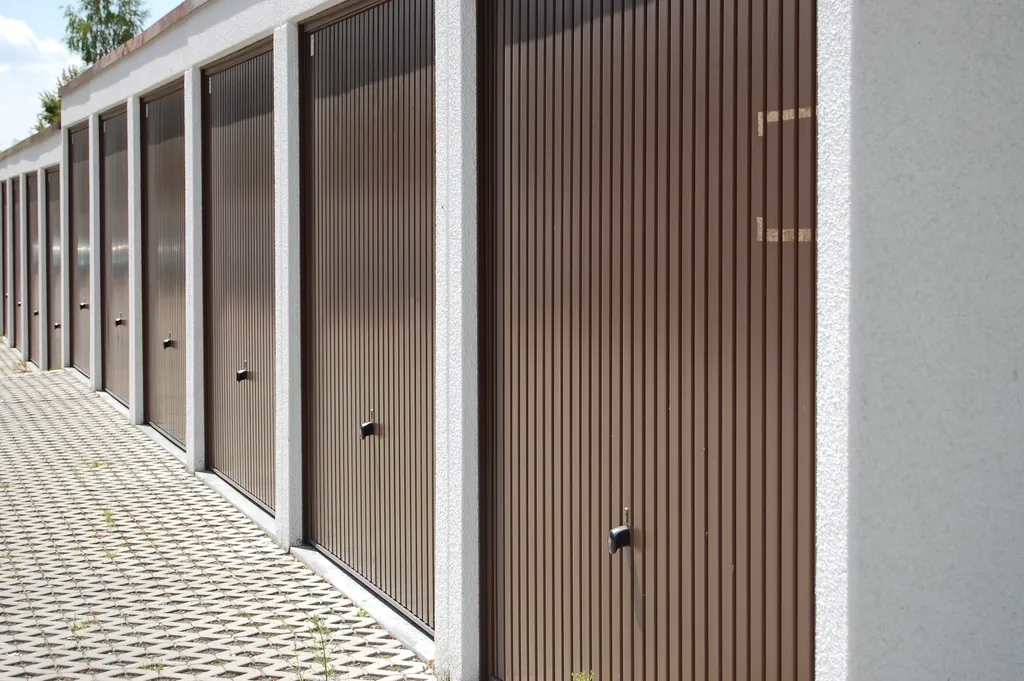 a row of closed garage doors along a paved walkway